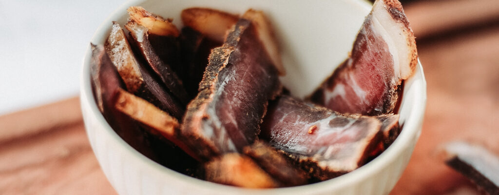 Bowl of Biltong on chopping board.