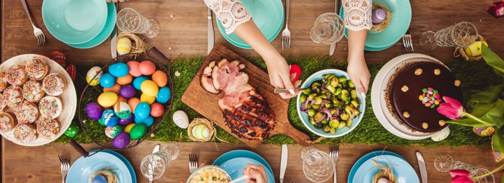 Table laid for Easter with different dishes and coloured Easter eggs
